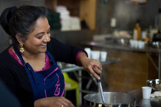 Photo of a South Asian woman leading a cooking demonstration on 伊甸堂校园